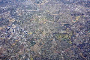 High altitude aerial photo showing dense urban cityscape with roads and green parks. jigsaw puzzle