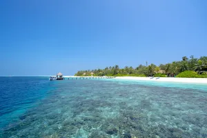 Stunning view of a tropical island beach with clear blue waters and lush greenery. jigsaw puzzle