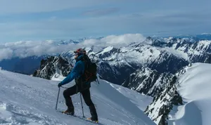 man in blue jacket and black pants riding ski blades on snow covered mountain during daytime jigsaw puzzle