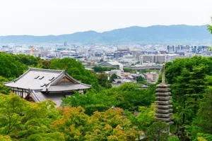 Japanese pagoda and cityscape amidst lush green trees jigsaw puzzle