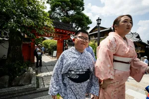 People in kimonos walk past a traditional japanese temple gate. jigsaw puzzle