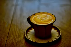 a cup of coffee sitting on top of a wooden table jigsaw puzzle