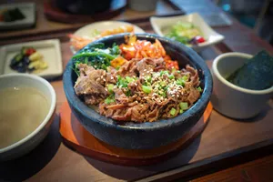 a bowl filled with meat and vegetables next to a bowl of soup jigsaw puzzle