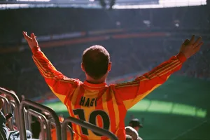 A man in an orange and yellow uniform at a soccer game jigsaw puzzle