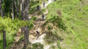 People biking down a steep, winding dirt path. jigsaw puzzle