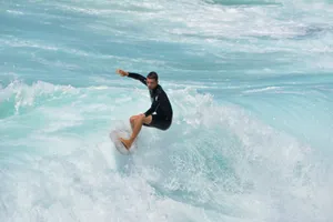 woman in black wetsuit surfing on sea waves during daytime jigsaw puzzle