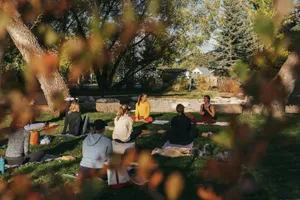 a group of people sitting on top of a lush green field jigsaw puzzle