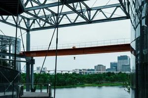Industrial structure with orange crane overlooking a river and city. jigsaw puzzle