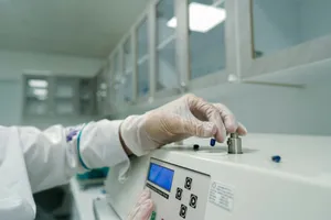 A person in a lab coat and gloves working on a machine jigsaw puzzle