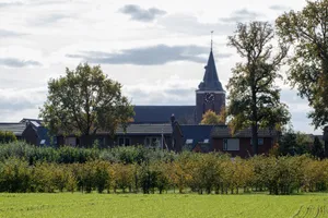 A picturesque rural village landscape featuring a charming church steeple among trees and houses. jigsaw puzzle