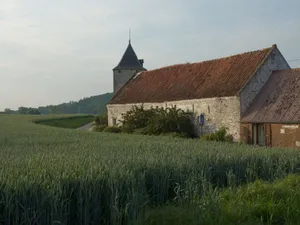 Charming stone church and farmhouse in lush green fields under a bright sky. jigsaw puzzle