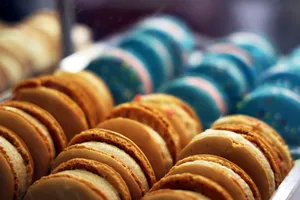 Close-up of variously colored macarons arranged in rows in a bakery setting. jigsaw puzzle
