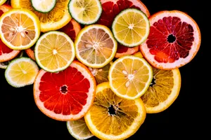 Colorful citrus fruit slices arranged against a black background, showcasing variety and freshness. jigsaw puzzle