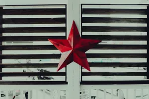 A vibrant red star adorns a rustic wooden lattice, adding charm and character. jigsaw puzzle