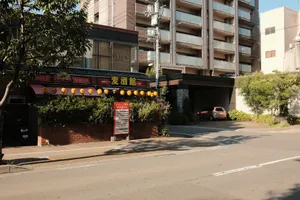 Image of a Japanese izakaya with lanterns, adjacent to a modern residential building. jigsaw puzzle