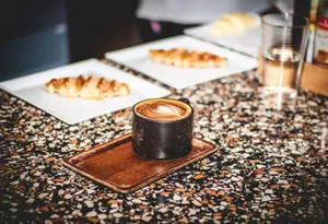 Artistic latte on a textured countertop with croissants, perfect for a cozy morning vibe. jigsaw puzzle