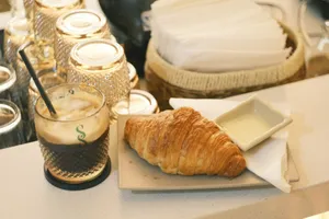 Delicious croissant with creamy dip and iced coffee set on a cafe counter. jigsaw puzzle