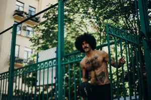 Tattooed man with afro hair holding a basketball in a street sportsground. jigsaw puzzle