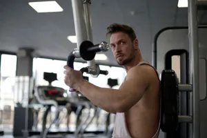 Focused man working out in a gym, showcasing biceps and determination. jigsaw puzzle