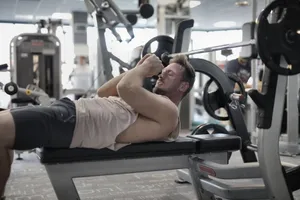 Focused muscular sportsman in modern sportswear preparing to workout with heavy barbell on bench training in modern gym jigsaw puzzle