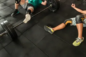Athletes resting on a gym floor beside heavy barbells after an intense weightlifting session. jigsaw puzzle