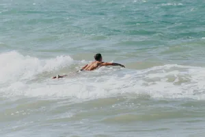 A man enjoys bodyboarding in the vibrant waves of Aracati beach, Brazil. jigsaw puzzle