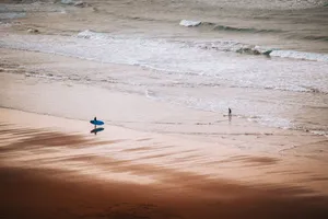 Surfer with blue surfboard walking on Bilbao beach, Spain, during summer. jigsaw puzzle