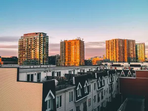 Captivating view of a modern city skyline with residential buildings illuminated by sunrise. jigsaw puzzle