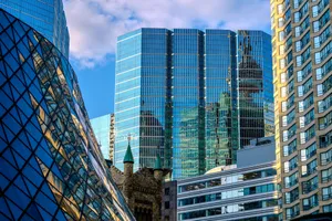 A vibrant cityscape featuring modern skyscrapers reflecting the blue sky and clouds. jigsaw puzzle