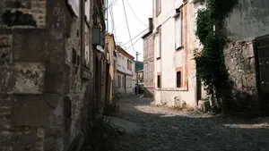 Charming cobblestone alley surrounded by rustic buildings in a historic old town setting. jigsaw puzzle