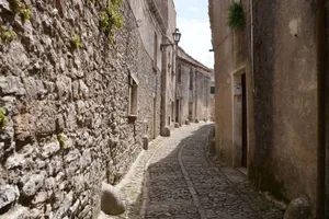 Explore a quaint cobblestone street surrounded by historical stone buildings in Erice, Sicily. jigsaw puzzle