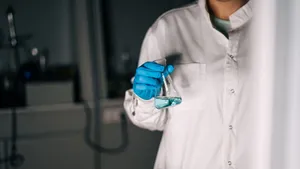 Scientist in white coat holding a flask with blue liquid in a laboratory, showcasing scientific research. jigsaw puzzle