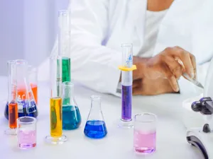 A scientist's hand working with colorful liquids in a laboratory setting. jigsaw puzzle