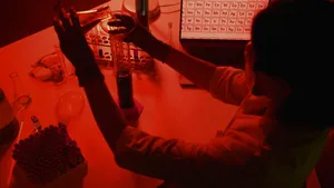 A scientist conducting experiments in a red-lit laboratory with various lab equipment. jigsaw puzzle