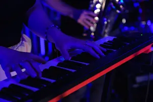 Musician performing on electronic keyboard at a live event with dramatic lighting. jigsaw puzzle