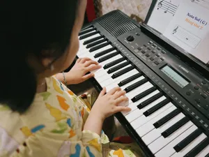 A young child practicing music on a digital keyboard indoors. jigsaw puzzle