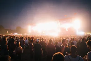 A lively music festival in Budapest with a large crowd enjoying bright stage lights at night. jigsaw puzzle