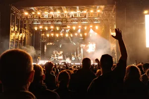 Energetic night concert with a cheering crowd and bright stage lights creating an electrifying atmosphere. jigsaw puzzle