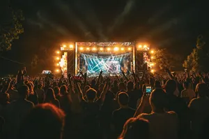 Large crowd enjoying a spectacular live outdoor concert at night with stage lighting effects. jigsaw puzzle