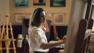 A female artist focuses intently while painting in a creative studio setting. jigsaw puzzle