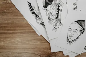 Top view of detailed black and white drawings on paper arranged on a wooden table. jigsaw puzzle