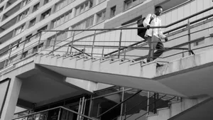 Monochrome image of a person on stairs in front of a modern urban building. jigsaw puzzle
