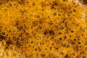 Detailed macro image of golden bubbles and foam creating a textured pattern. jigsaw puzzle