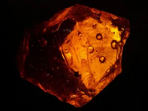 A beautifully illuminated orange amber stone with detailed textures and patterns. jigsaw puzzle