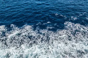 Aerial view of the ocean's dynamic waves and seafoam, showcasing its vibrant blue hues. jigsaw puzzle