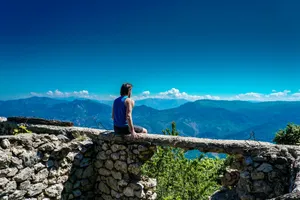 man sitting on gray concrete cliff jigsaw puzzle