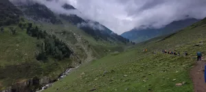a group of people walking on a path in a grassy valley jigsaw puzzle
