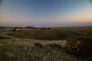 a grassy field with rocks and grass in the foreground jigsaw puzzle