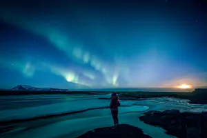 man standing on rock formation under blue sky during night time jigsaw puzzle