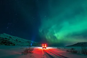 a car driving down a snow covered road under a green light jigsaw puzzle